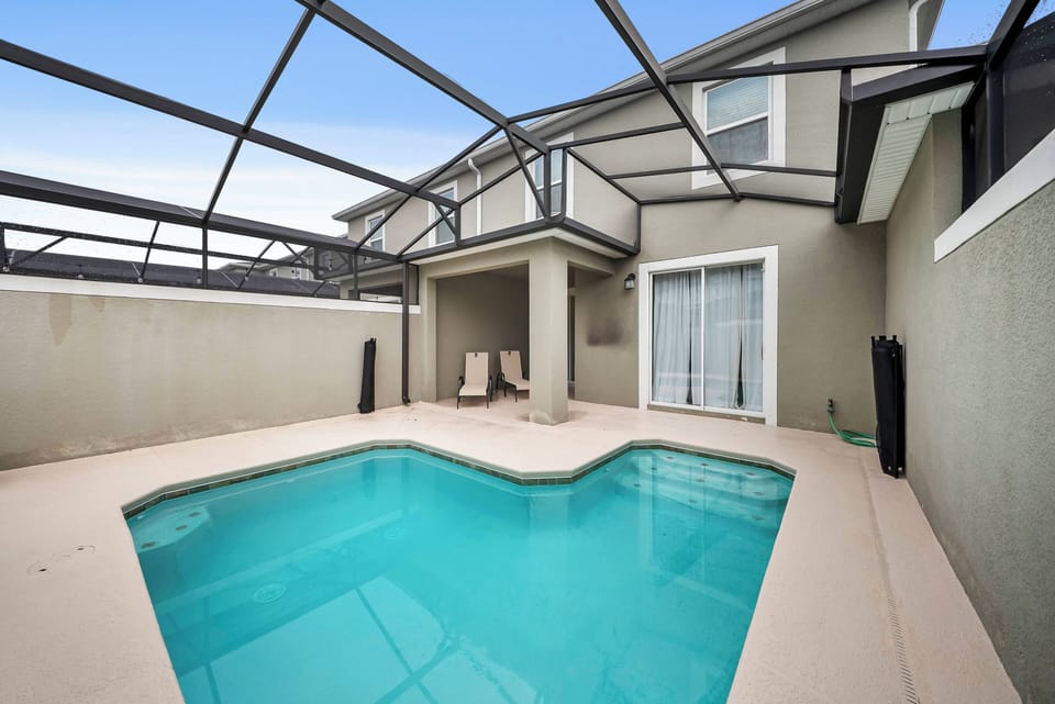 Step into your private oasis with a sparkling pool inside a sleek screened enclosure. Relax in comfortable seating as sunlight dances on the water, creating a tranquil atmosphere in this inviting outdoor retreat.