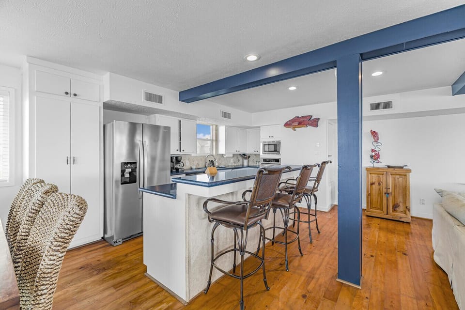 Spacious full kitchen with dining table seating for 8 and additional bar seating for 3 — perfect for gathering, cooking, and shared meals.