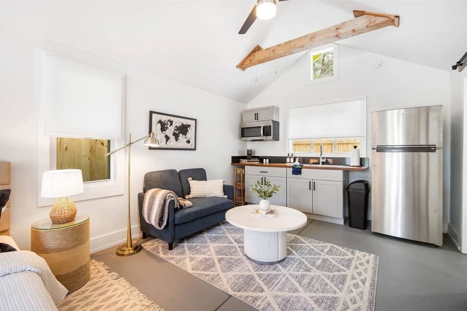 Bright, spacious, and modern living area featuring a comfortable couch, TV, and a fully-equipped kitchenette for your convenience.