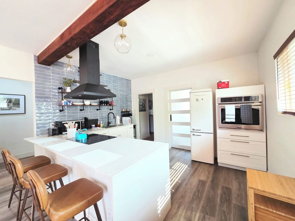 Bright modern kitchen with waterfall island, bar seating, and designer touches