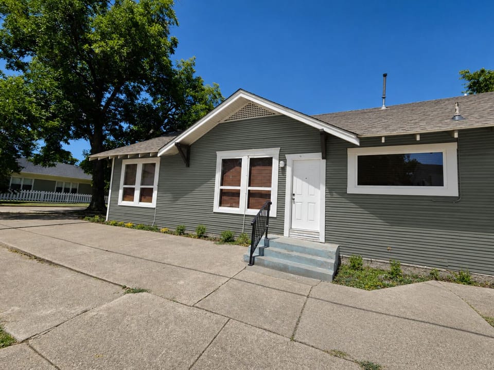 Charming exterior with private entry, wide driveway, and mature shade trees