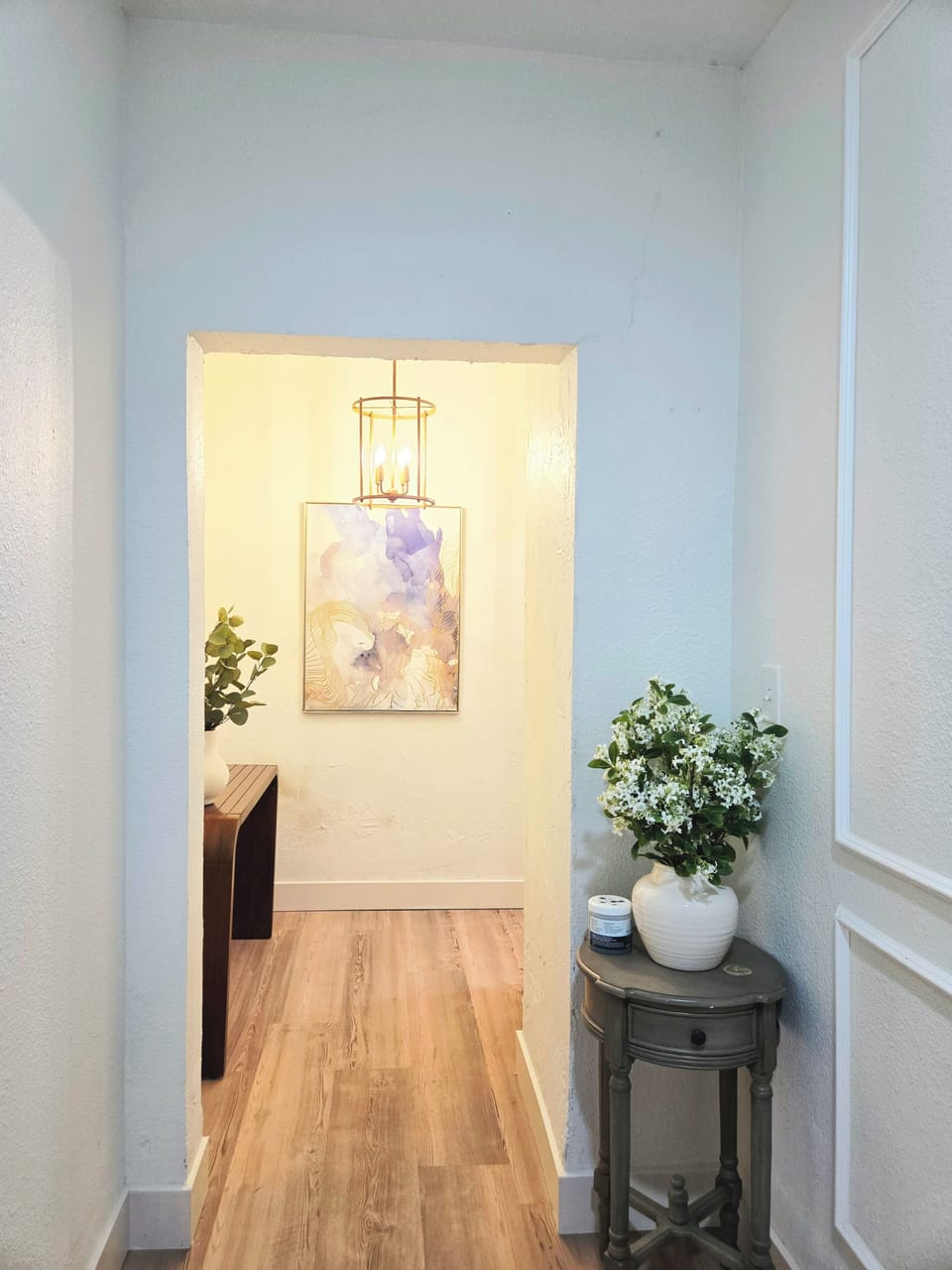 Bright, elegantly styled hallway with warm lighting and charming decor