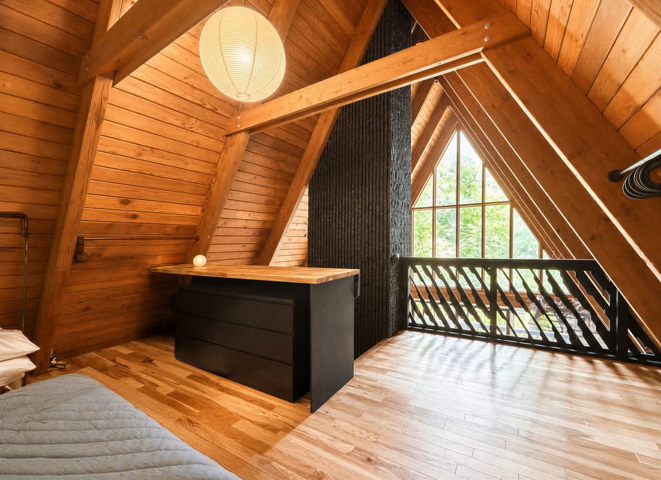 Wake up in the loft bedroom surrounded by warm wood ceilings and forest views.