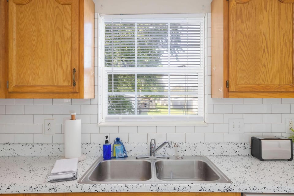 Bright kitchen with sunny window, double sink, and clean modern finishes