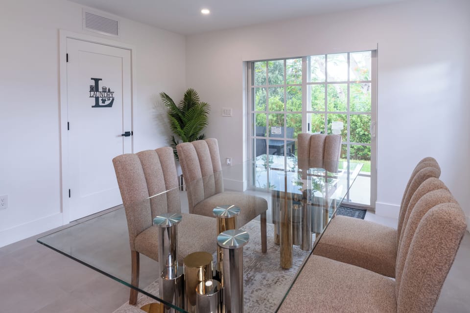 Bright modern dining area with glass table and garden-view sliding doors