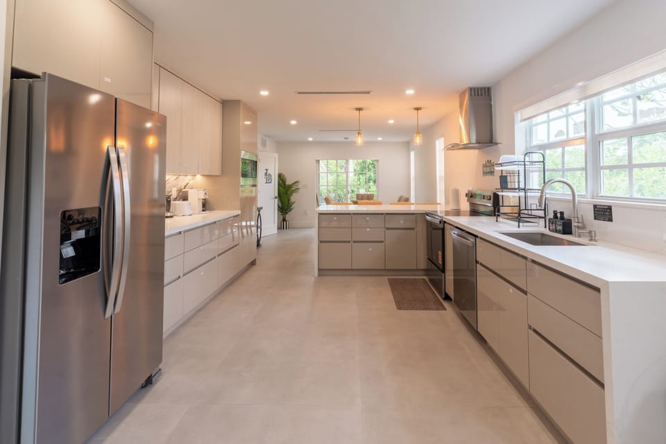 Bright modern kitchen with island, stainless appliances, and ample light