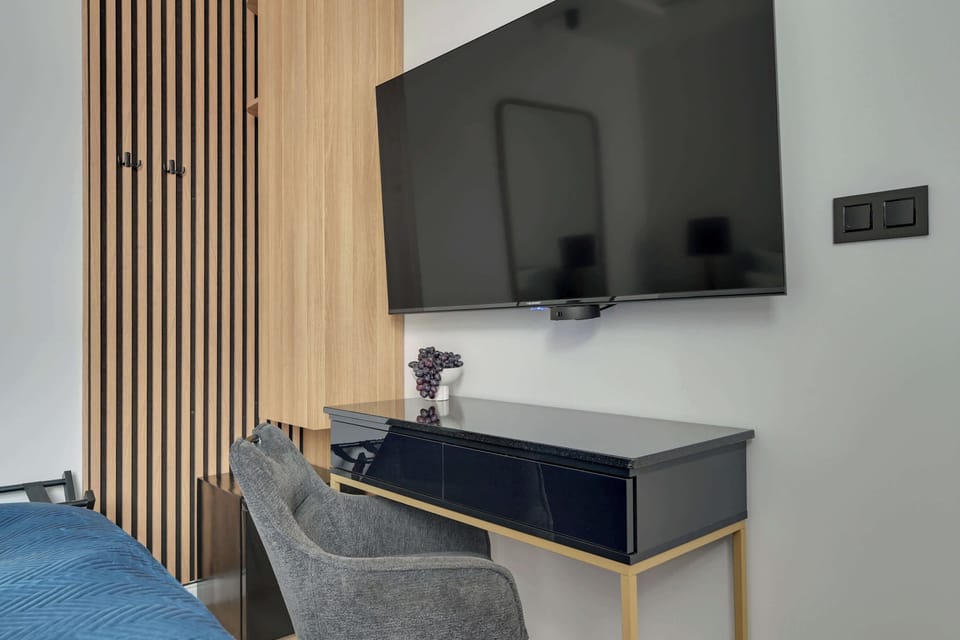 W pokoju znajduje się wygodne łóżko małżeńskie przygotowane z hotelową pościelą i kompletem poduszek oraz telewizor Smart TV z dostępem do kanałów satelitarnych. Do dyspozycji gości przygotowano również miejsce do przechowywania ubrań.