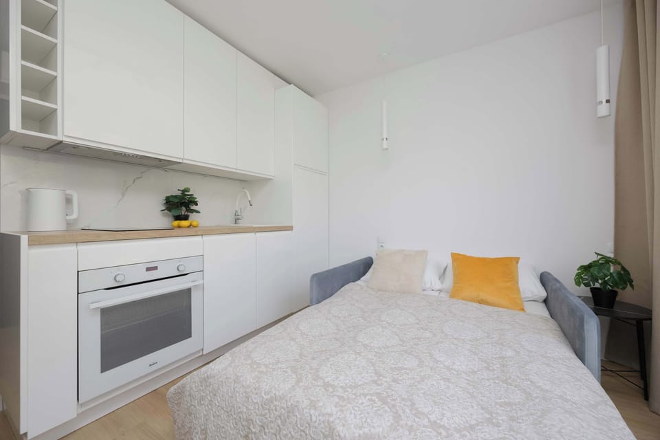 Cozy sleeping area with a comfortable bed, bedside table, and soft yellow decorative cushion.