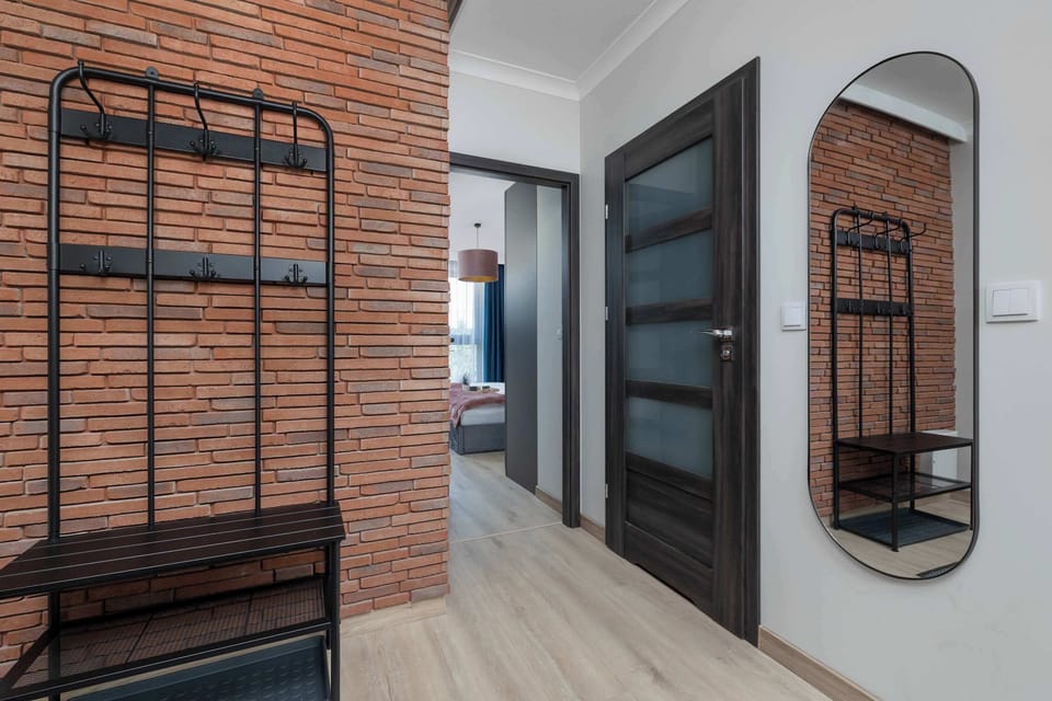 Modern hallway with decorative mirrors, built-in storage, and industrial-style accents.