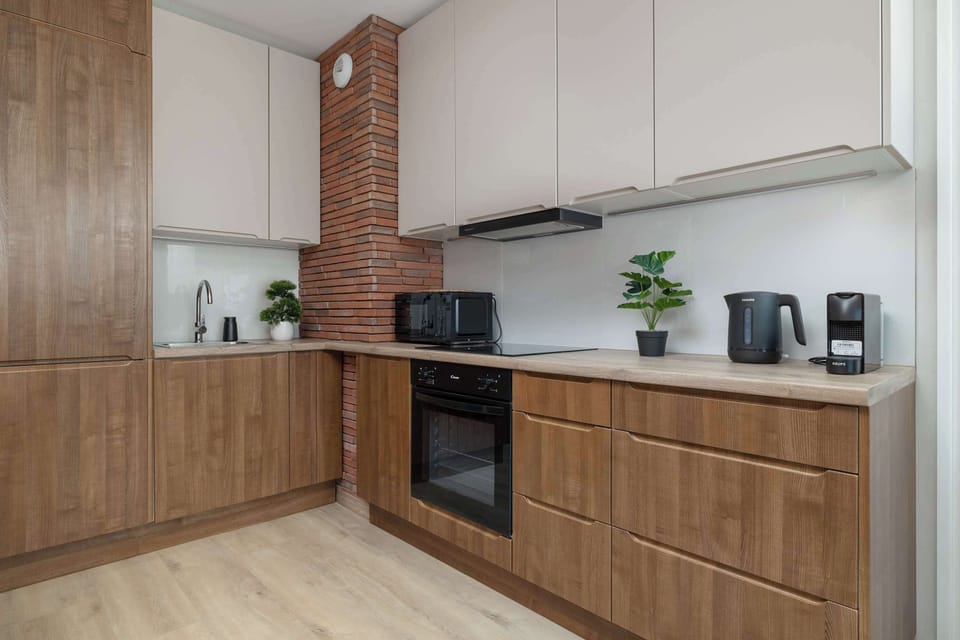 Fully equipped kitchen with modern appliances, ample storage, and sleek wooden cabinetry.