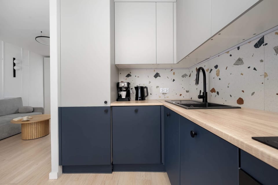 A view of the kitchen corner highlighting the sink area and upper storage cabinets. The open floor layout smoothly connects the kitchen to the rest of the living space.