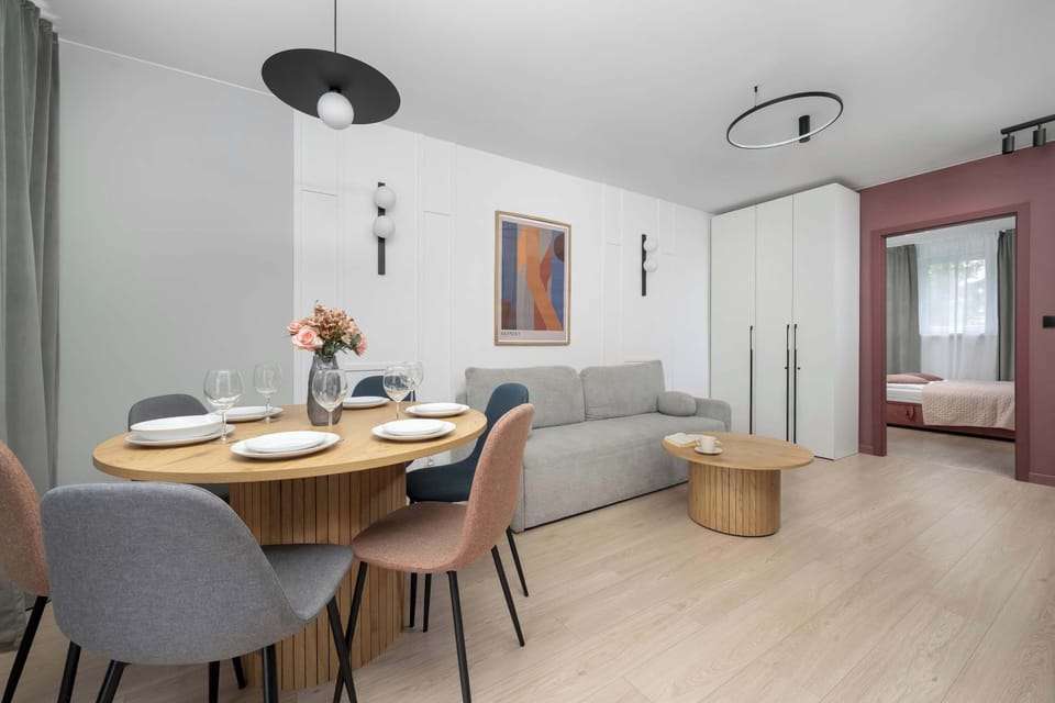 A wider shot of the dining space seamlessly flowing into the main living room. Balanced lighting and clean lines enhance the modern aesthetic.