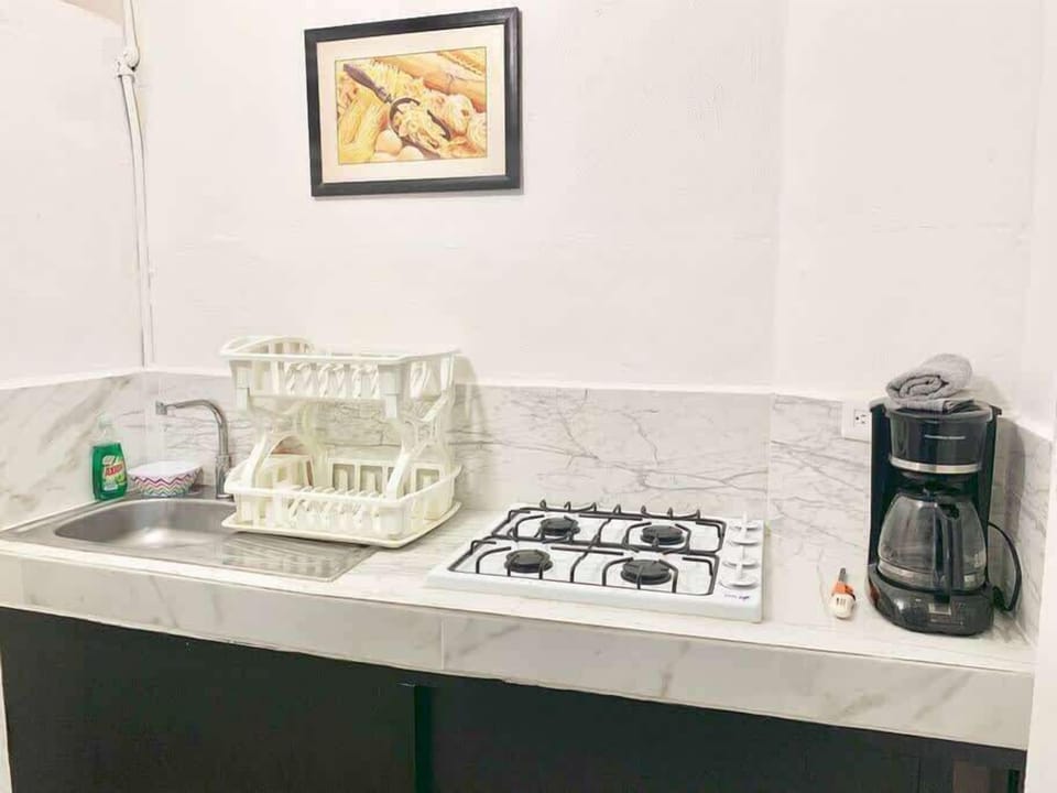 Kitchen counter with gas stove, coffee maker and kettle