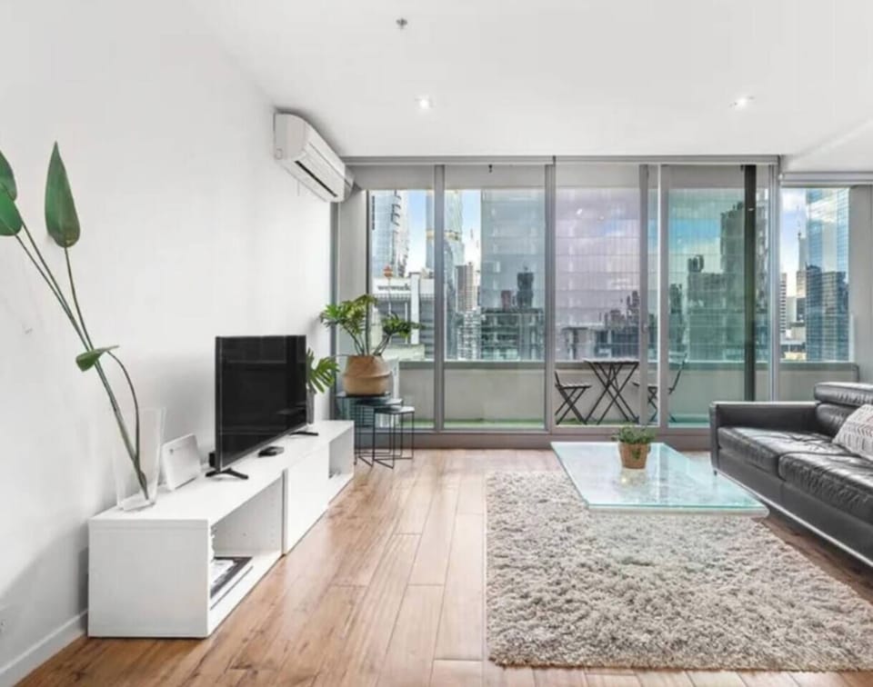 Unwind on the leather sofa in the open-plan living area, complete with expansive windows and skyline views that bring Melbourne’s energy inside.