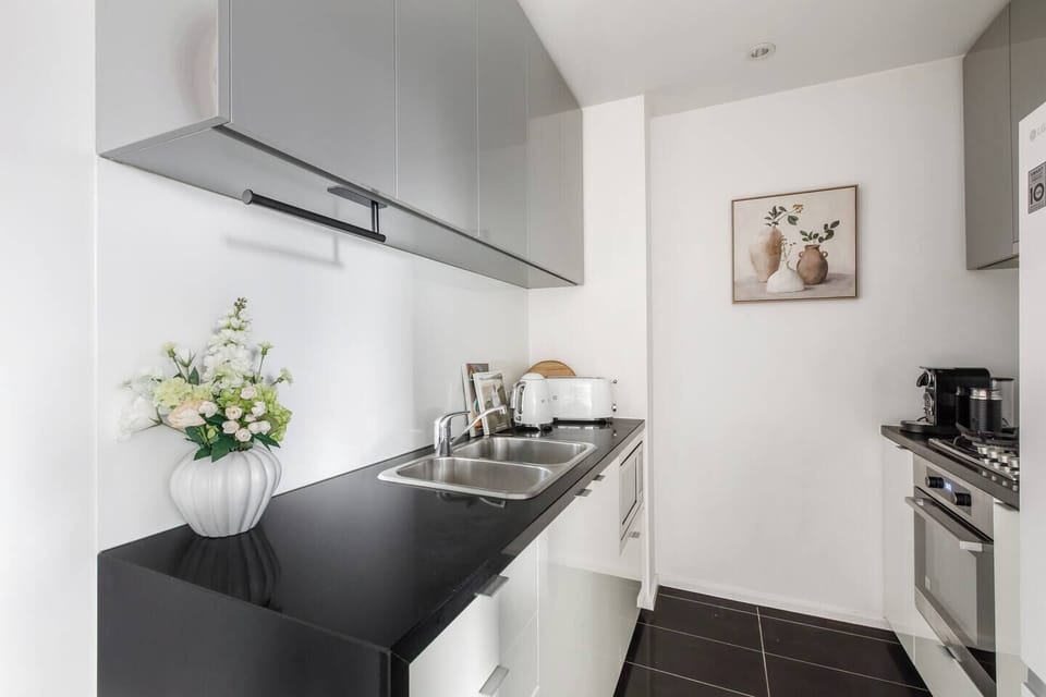 Prepare effortless meals in the compact kitchen, complete with glossy cabinetry, an oven, a toaster, a full-sized fridge, and all the essentials for home-style cooking.