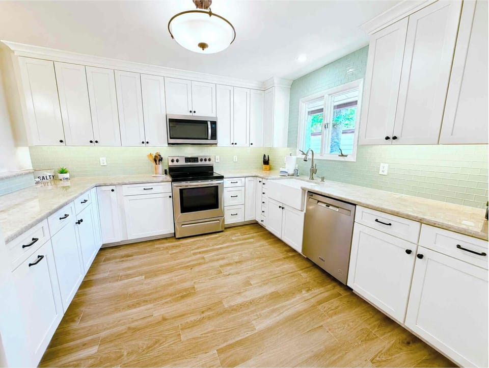 Full kitchen with ample counter space, farmhouse sink, open to dining rooom
