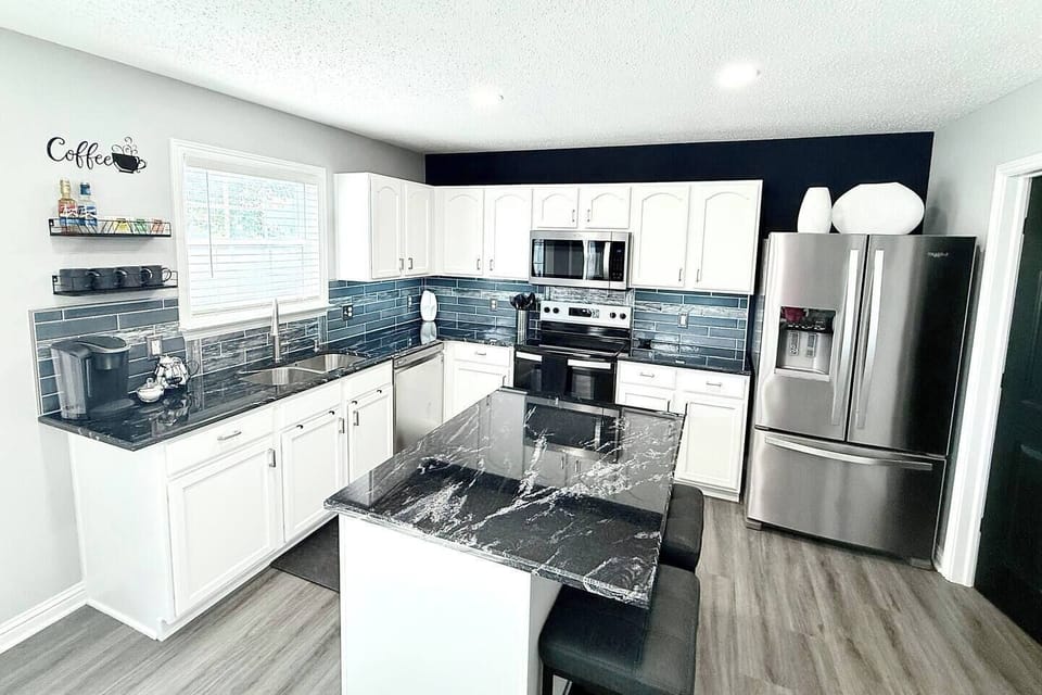 Kitchen with 2 bar stools at the island, under cabinet lighting, and dimmable canned lighting.