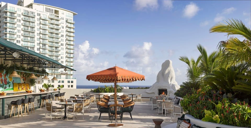 Rooftop bar with vibrant decor, comfortable seating, and scenic ocean views stretching to the horizon
