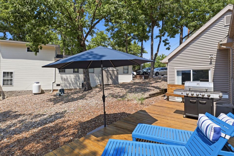 Sunny private deck with grill, loungers, and peaceful wooded surroundings
