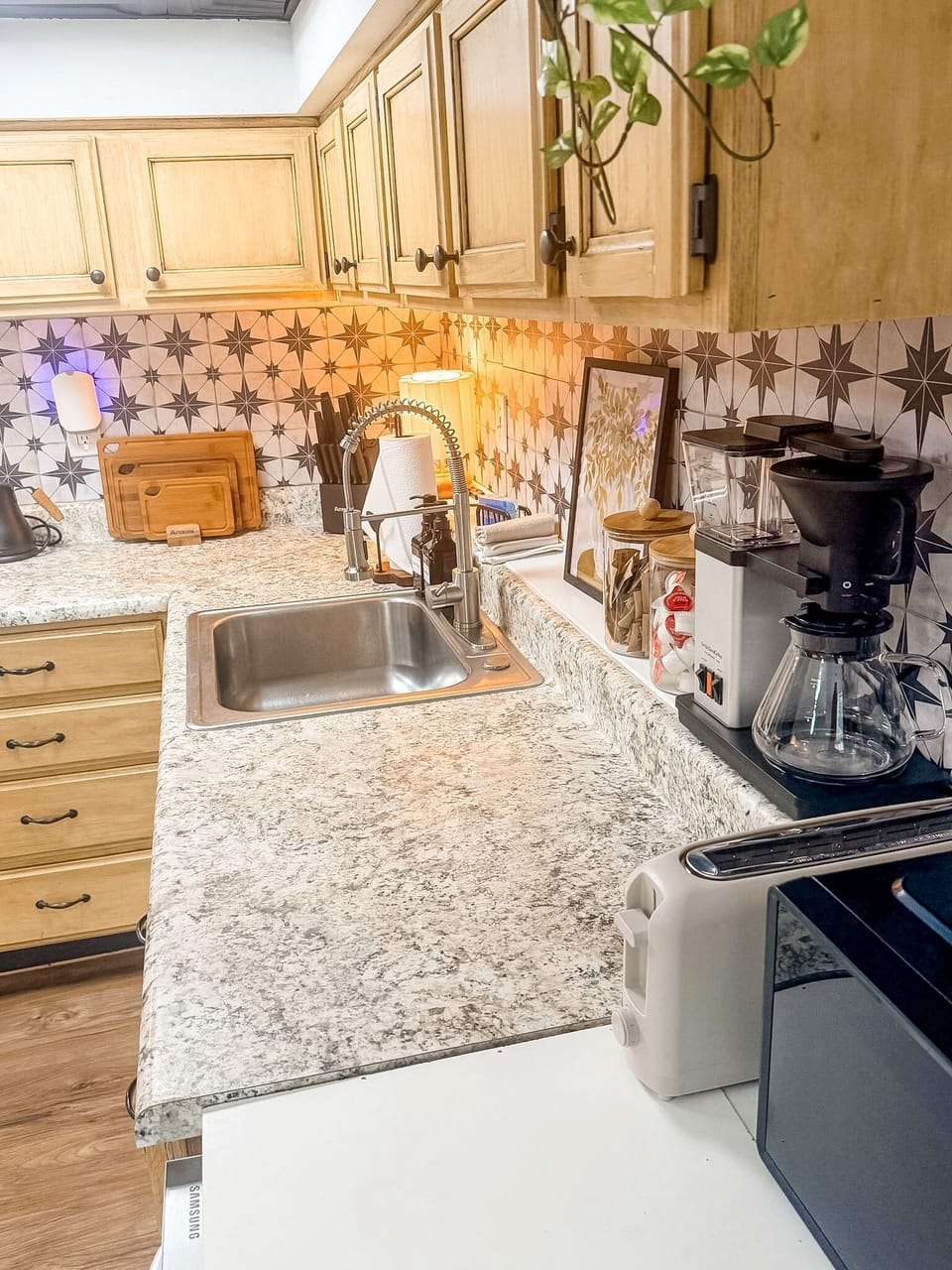 Bright kitchenette with coffee station, modern backsplash, and ample counter space