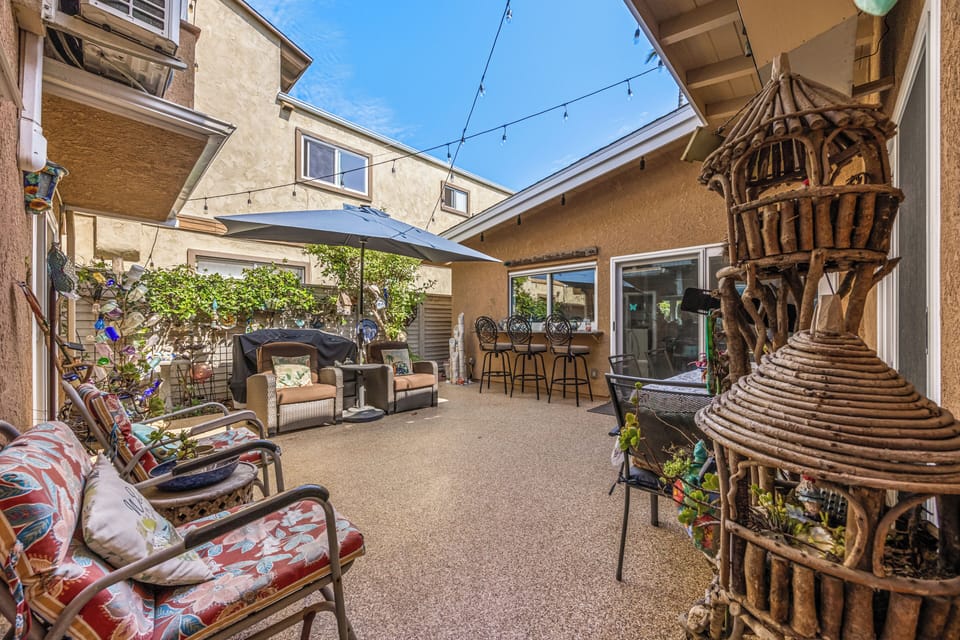 Unwind under ambient string lights, complete with umbrella-covered wicker seating and outdoor dining tables just steps from your door.