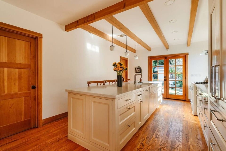 Well-appointed kitchen island with ample prep space, warm wood details, and natural light — ideal for cooking and gathering.