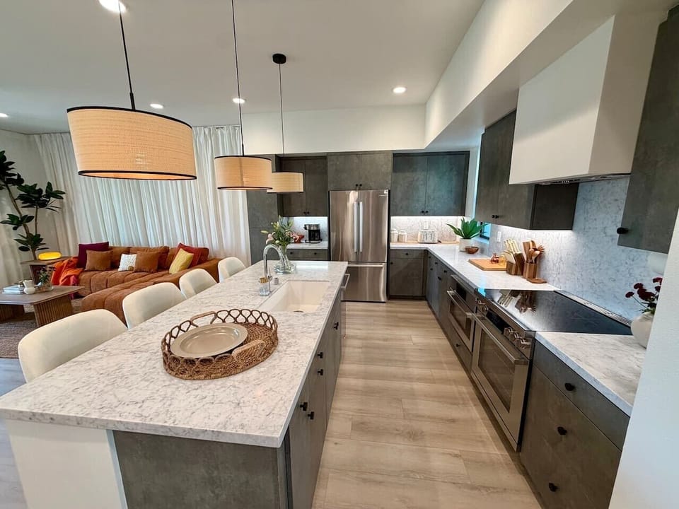 Dark cabinetry, marble countertops, and a full range of stainless appliances make this kitchen ready for everyday cooking or entertaining.