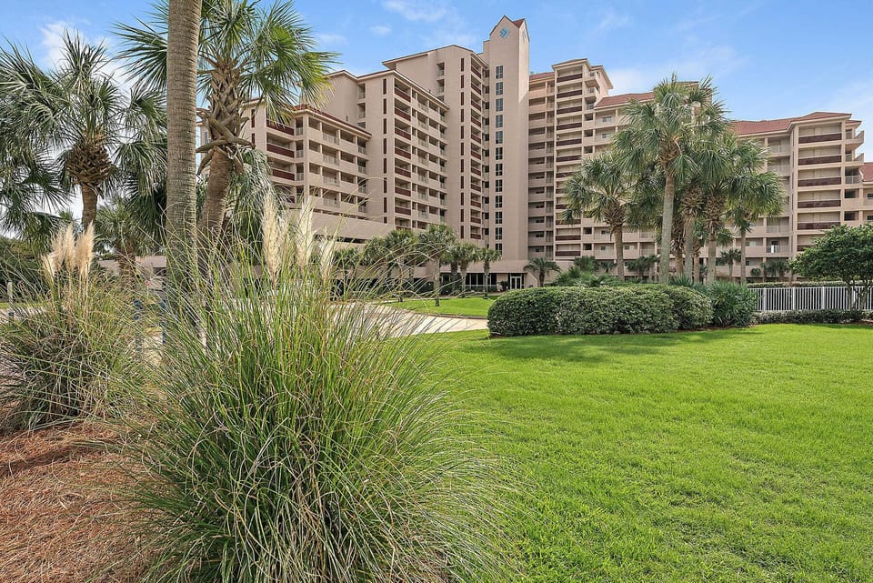 Beach Manor at Tops'l Beach & Racquet Resort features beautifully maintained tropical landscaping, lush green spaces, and a relaxing resort atmosphere just steps from the sugar-white sands of Miramar Beach.