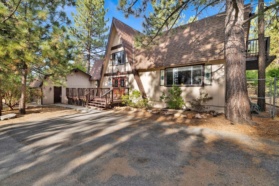 Welcoming mountain home entry surrounded by towering pine trees, offering fresh mountain air and a peaceful forest setting the perfect first impression for your Big Bear Lake getaway.