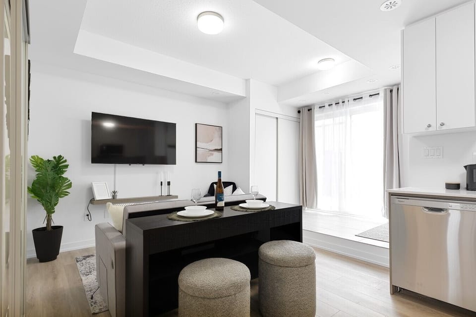 Relax in the bright, open-concept living space designed for both comfort and functionality. Floor-to-ceiling patio doors fill the suite with natural light, while the comfortable seating area and Smart TV make it easy to unwind after a busy day. The dining