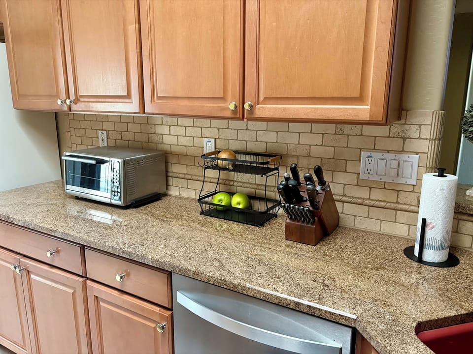 Toaster oven, plenty of dishes, glassware, towels, utensils