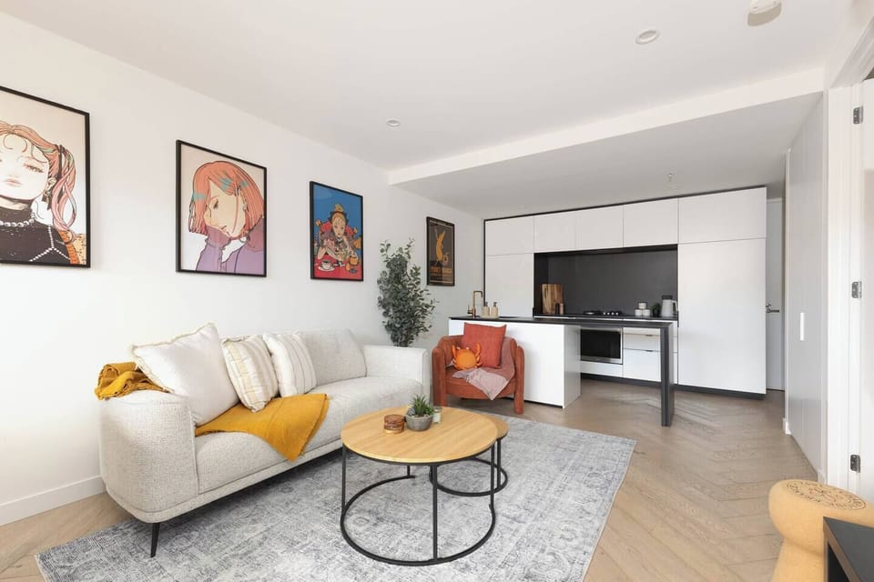 Step into a thoughtfully designed apartment where an open-plan living area flows into bedrooms and a private balcony, creating a seamless retreat above Fitzroy’s buzzing streets.