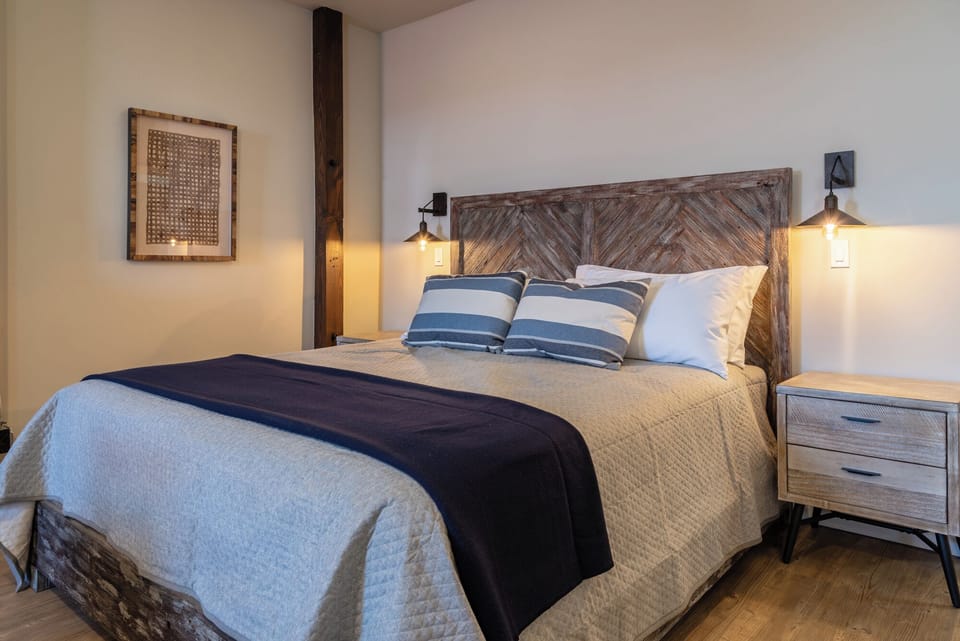 Striped accent pillows and warm lighting bring a cozy feel to the bedroom.