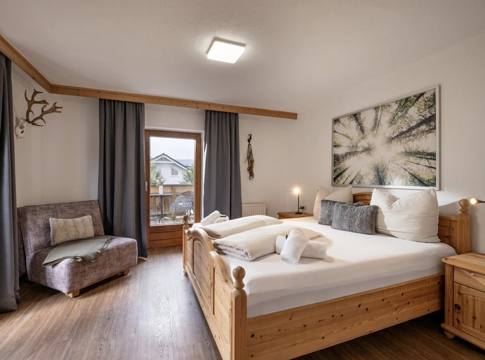 Westendorf vacation apartment with bright bedroom, queen-style bed, sofa and quiet setting close to the village center, ski bus and Alpine trails.