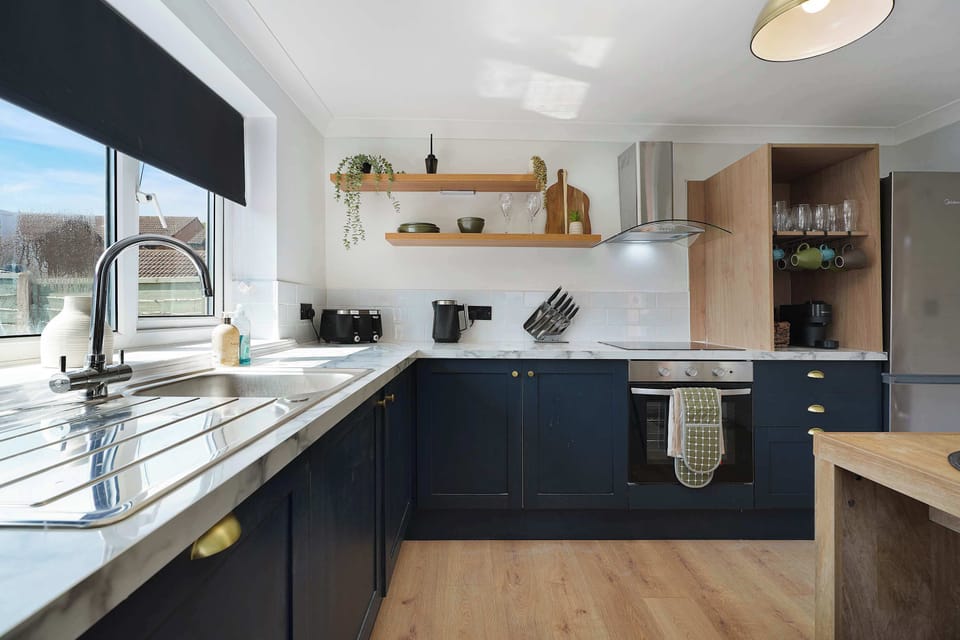 Cook with ease in the well-equipped kitchen, featuring an oven, hob, microwave, fridge/freezer, washing machine, breakfast table, and all the essential cookware for everyday meal preparation.