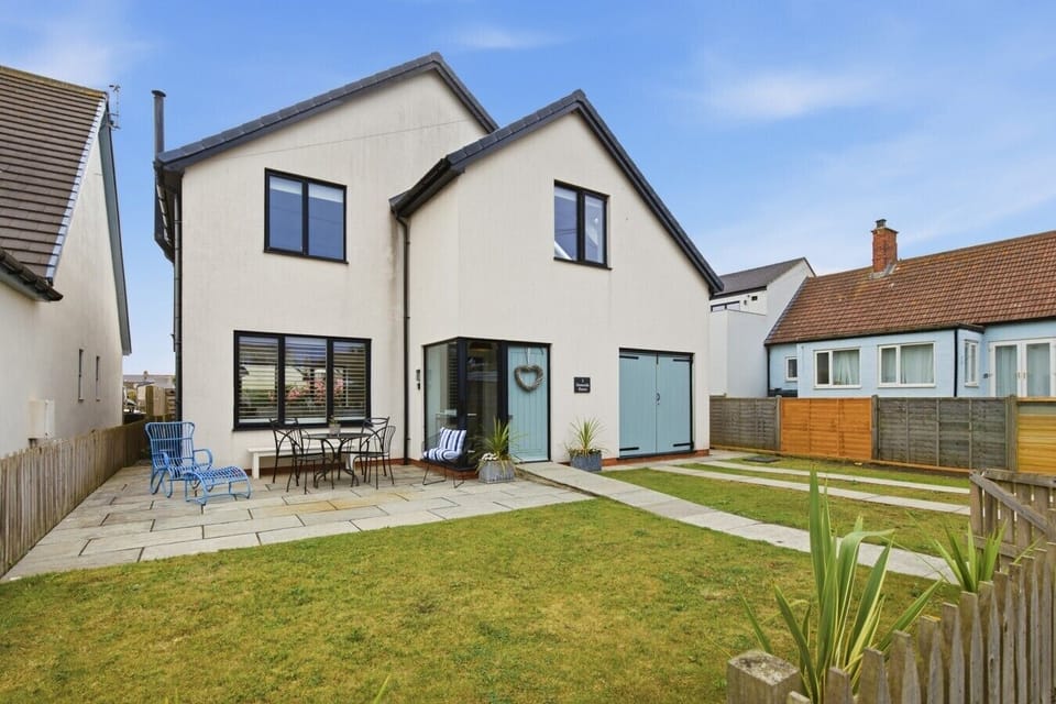 Contemporary rear elevation with lawn, paved patio and outdoor seating area
