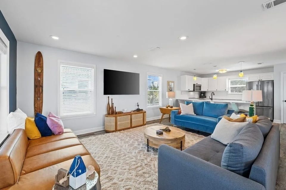 Sink into plush seating and enjoy movie nights in this airy, open-concept living space, thoughtfully designed with vibrant decor and a seamlessly connected modern kitchen.