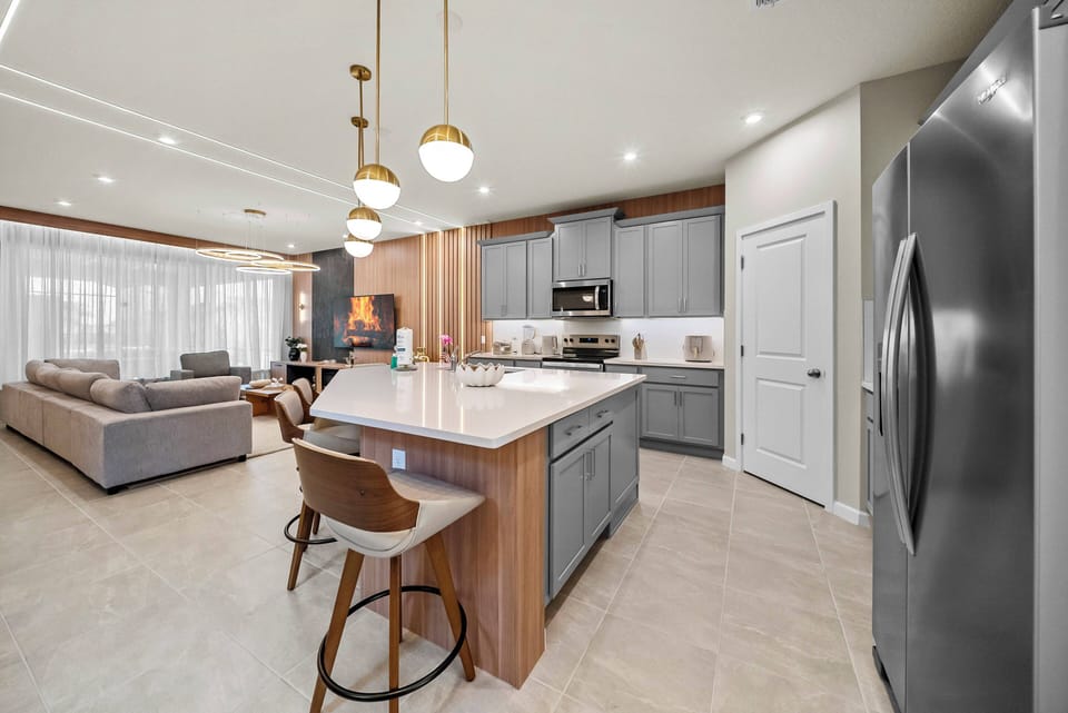 Welcome to this beautiful kitchen with sleek gray cabinetry and warm wood accents. The spacious island is ideal for casual dining, and the generous natural light creates a charming space for family gatherings and entertaining.
