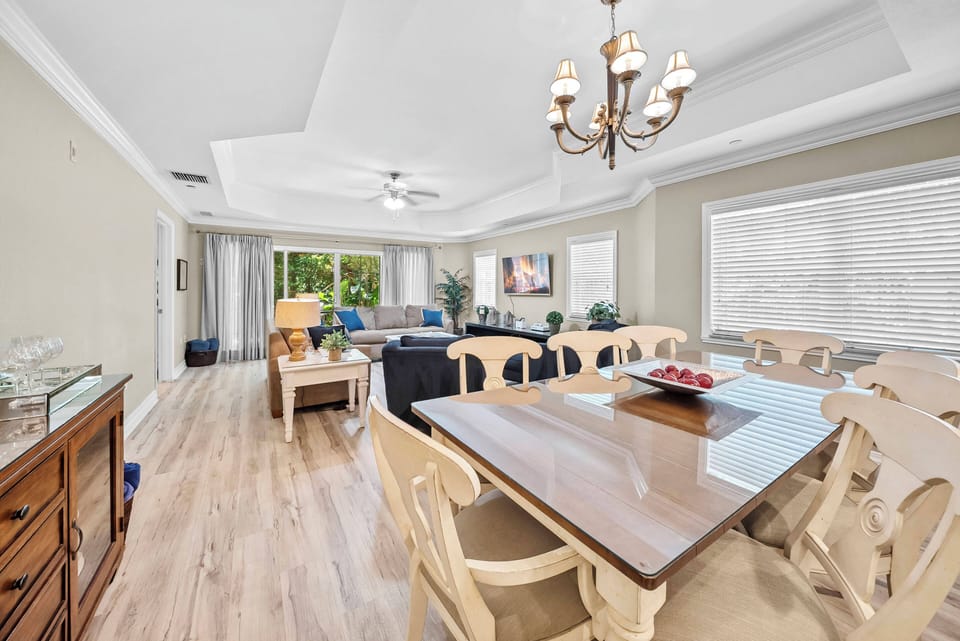 Enjoy our spacious dining area, where a polished wooden table and elegant cream chairs invite you to gather. With natural light streaming in from large windows, it creates a warm atmosphere ideal for sharing meals and memories.