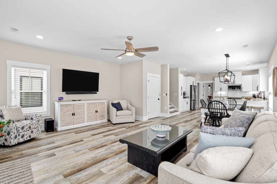 Sink into soft seating in your light-filled living area, where an open layout connects seamlessly to the full kitchen and dining space—perfect for gathering and unwinding together.