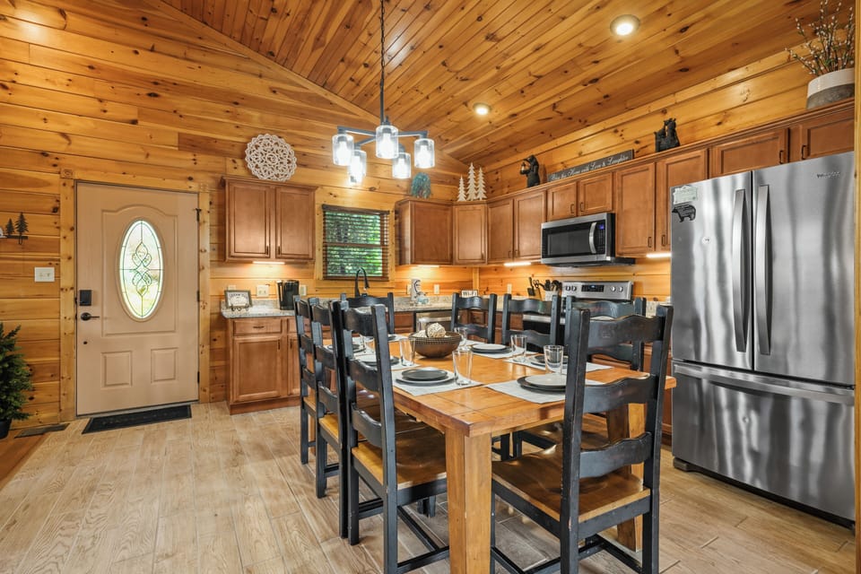 Rustic cabin kitchen with vaulted wood ceilings and dining for 8