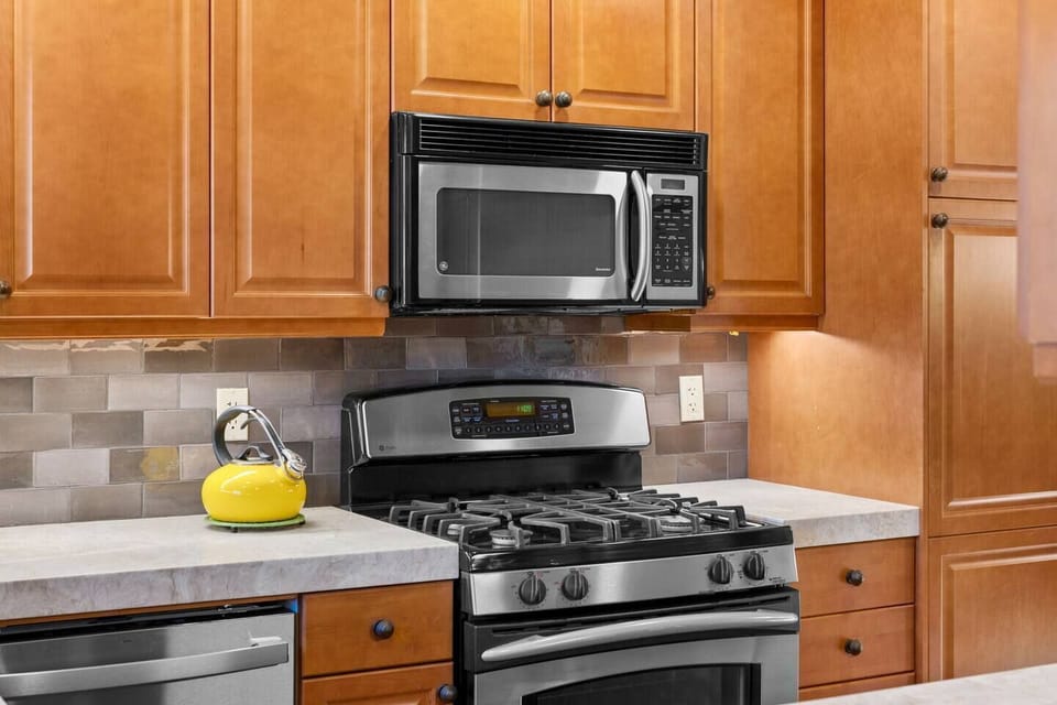 Gas range and oven with overhead microwave. Lovely yellow teapot