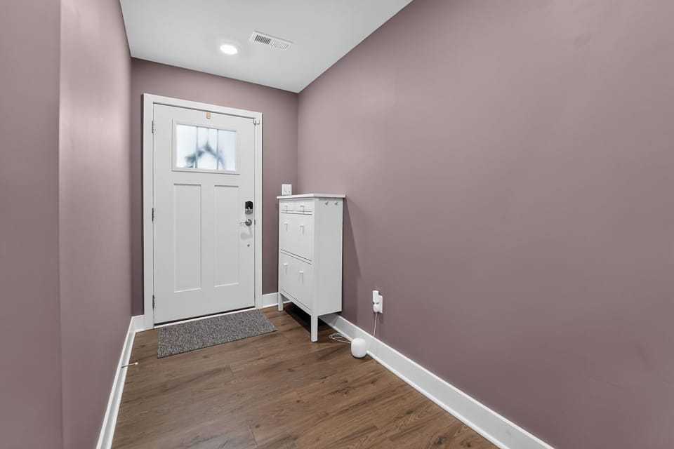 Bright, stylish entryway with frosted glass door and handy storage