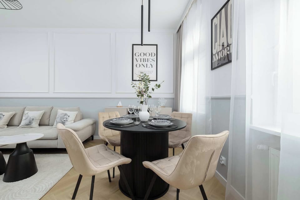 A bright dining and relaxation area with a round table and elegant chairs.