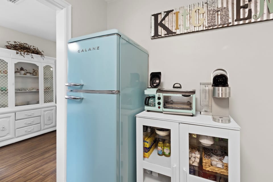 Brew your morning cup at the coffee station stocked with a Keurig, drip maker, and toaster oven, all beside a charming retro fridge.