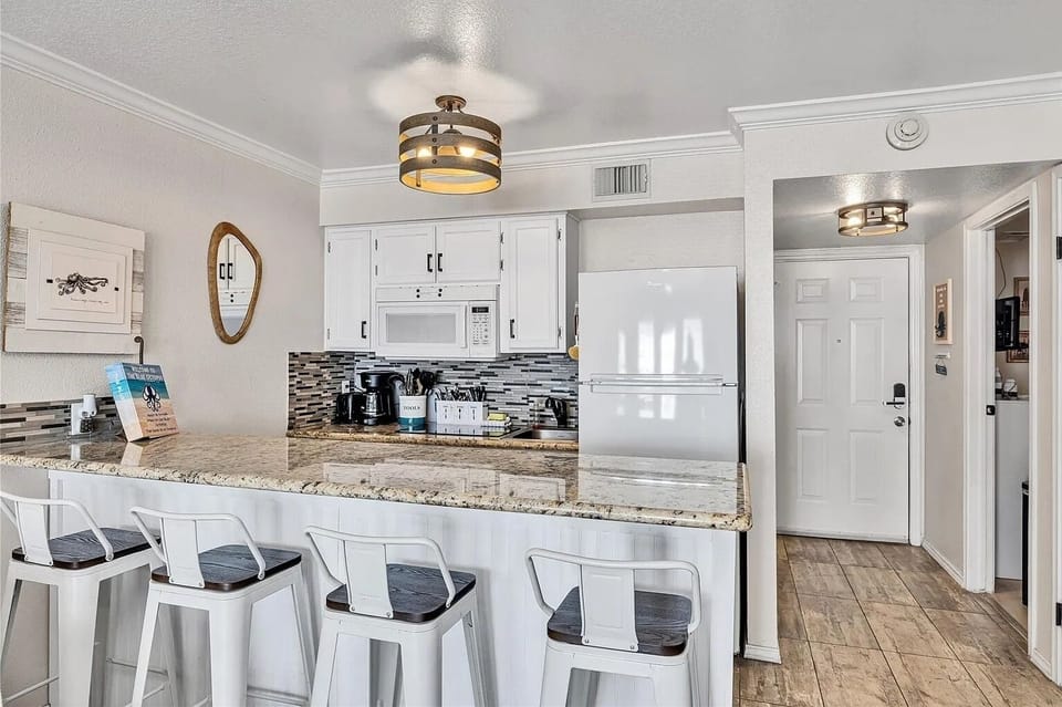 Bright updated kitchen with granite bar seating for four