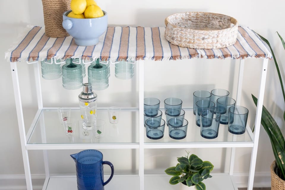 Stylish beverage station with glassware and fresh coastal-inspired decor