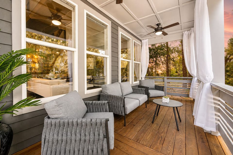 Relax on the breezy covered porch with lounge seating and serene tree views