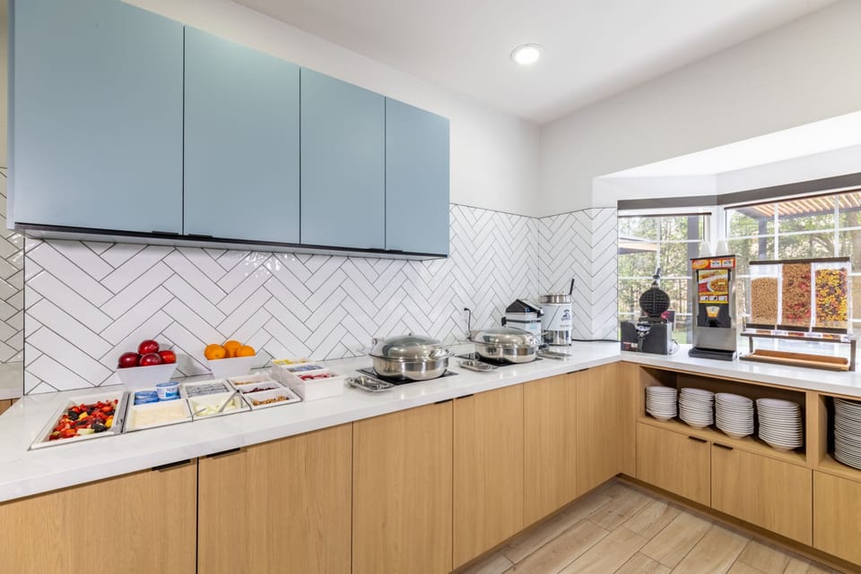 Complimentary hot breakfast buffet with chafing dishes, fresh fruit, and waffle station.