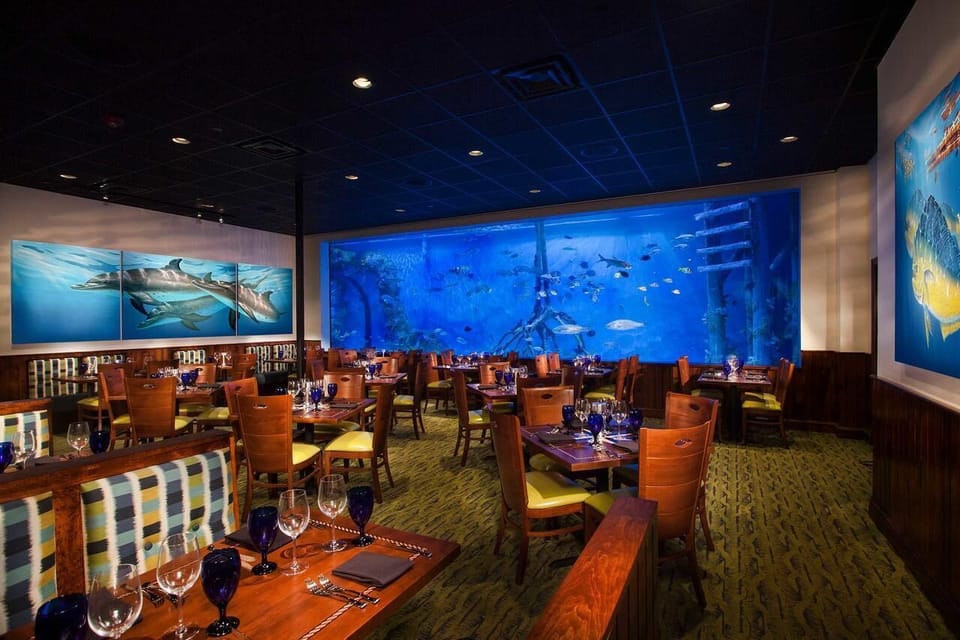 Savor dinner with panoramic aquarium views and warm lighting.